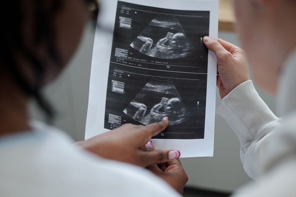 Expectant parents reviewing prenatal ultrasound images showing fetal heart development, representing a missed congenital heart defect malpractice claim