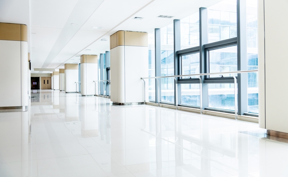 Image Bright, empty hospital corridor with large windows and handrails, illustrating winter hospital short-staffing and patient safety concerns in Pennsylvania.