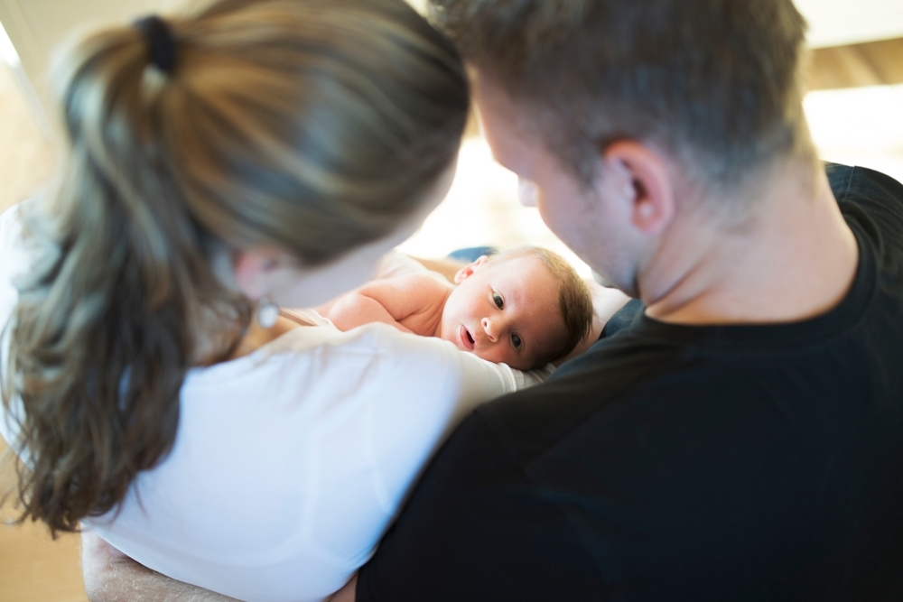 Image Parents holding their newborn baby, representing how a birth injury can affect a marriage and lead to loss of consortium damages in a lawsuit
