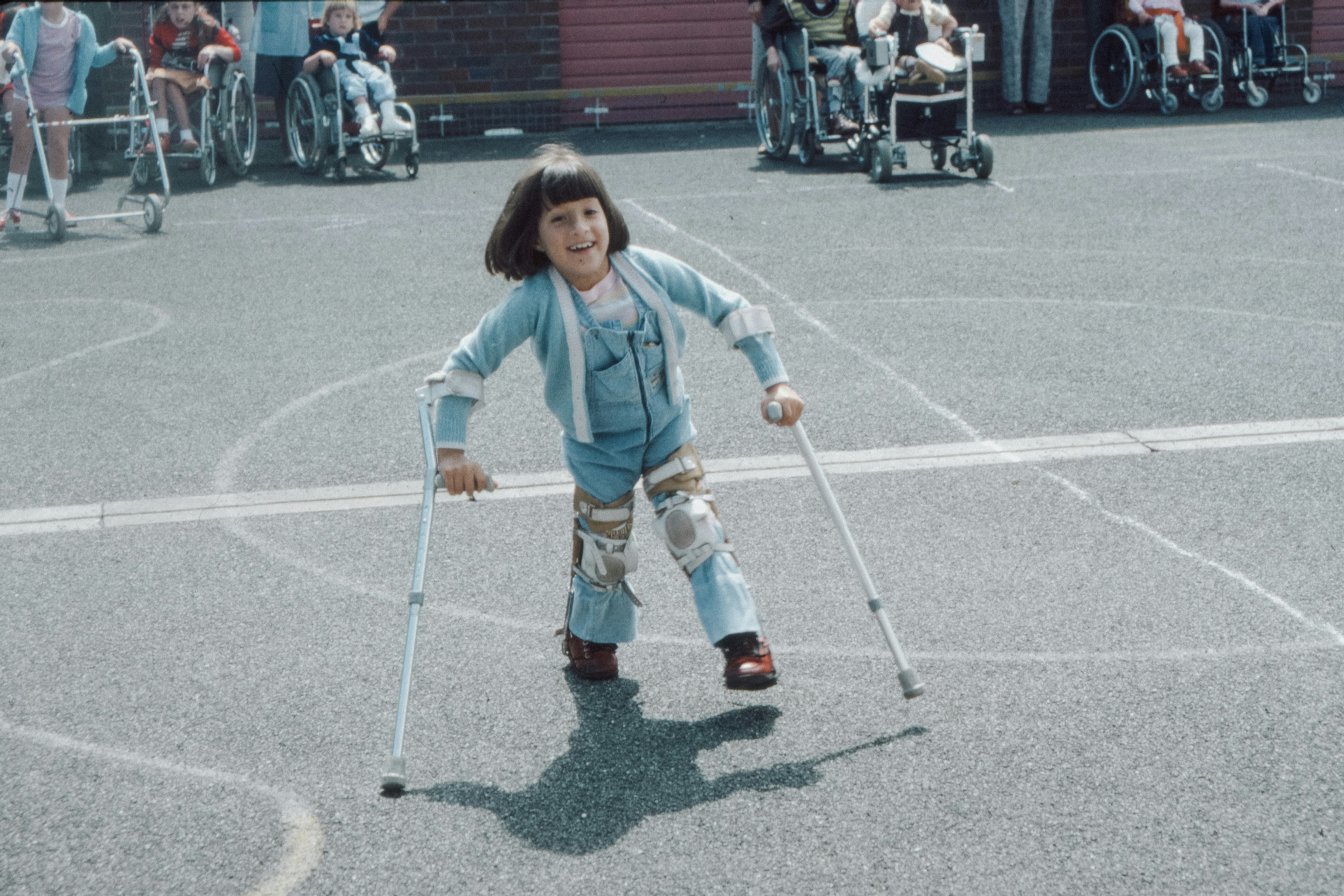 Image Child with leg braces using crutches outdoors, representing mobility challenges and the need for accessible home modifications for cerebral palsy
