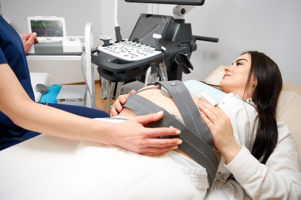 A medical professional uses electronic fetal monitoring (EFM) to track a baby’s heart rate, generating the critical heart rate strips that can reveal the hidden truth behind a preventable birth injury.