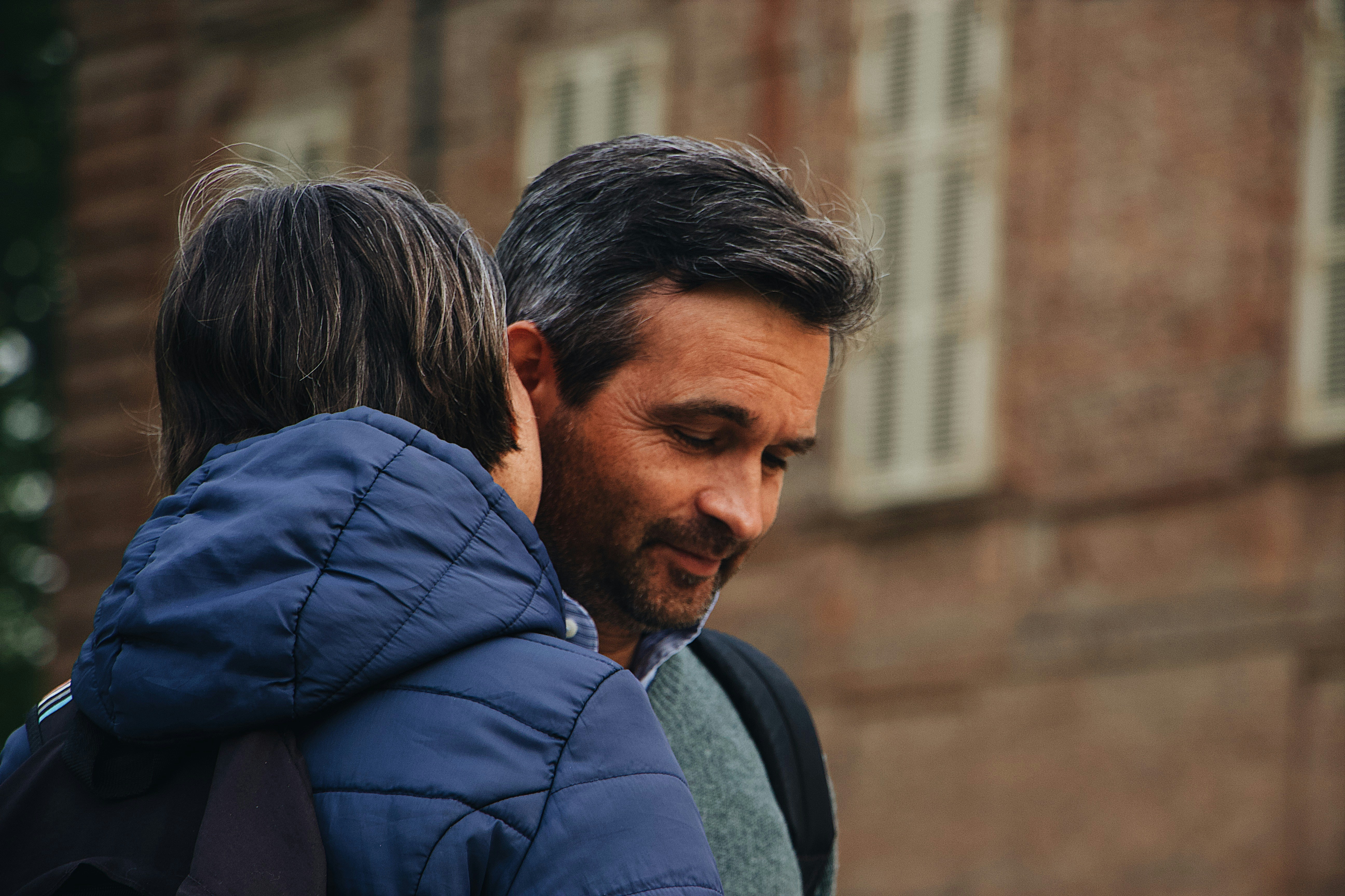Image Parent comforting a child while discussing a birth injury and family changes outdoors