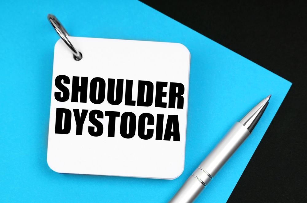 A notepad displaying "Shoulder Dystocia," a medical emergency where a baby's shoulder gets stuck during delivery, potentially leading to birth injuries.