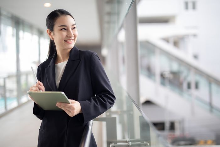 Excited office worker looking up from her tablet device.
