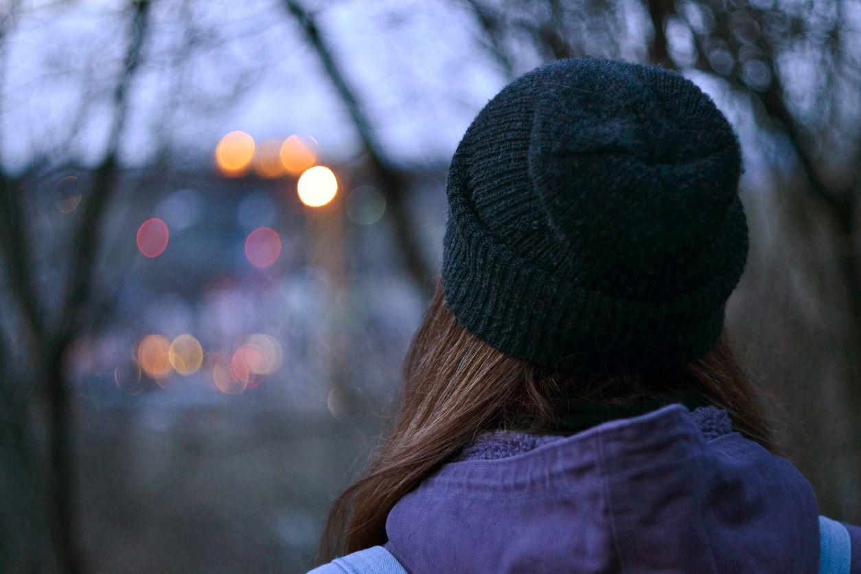 Portrait of a woman wearing a cap taken from behind.