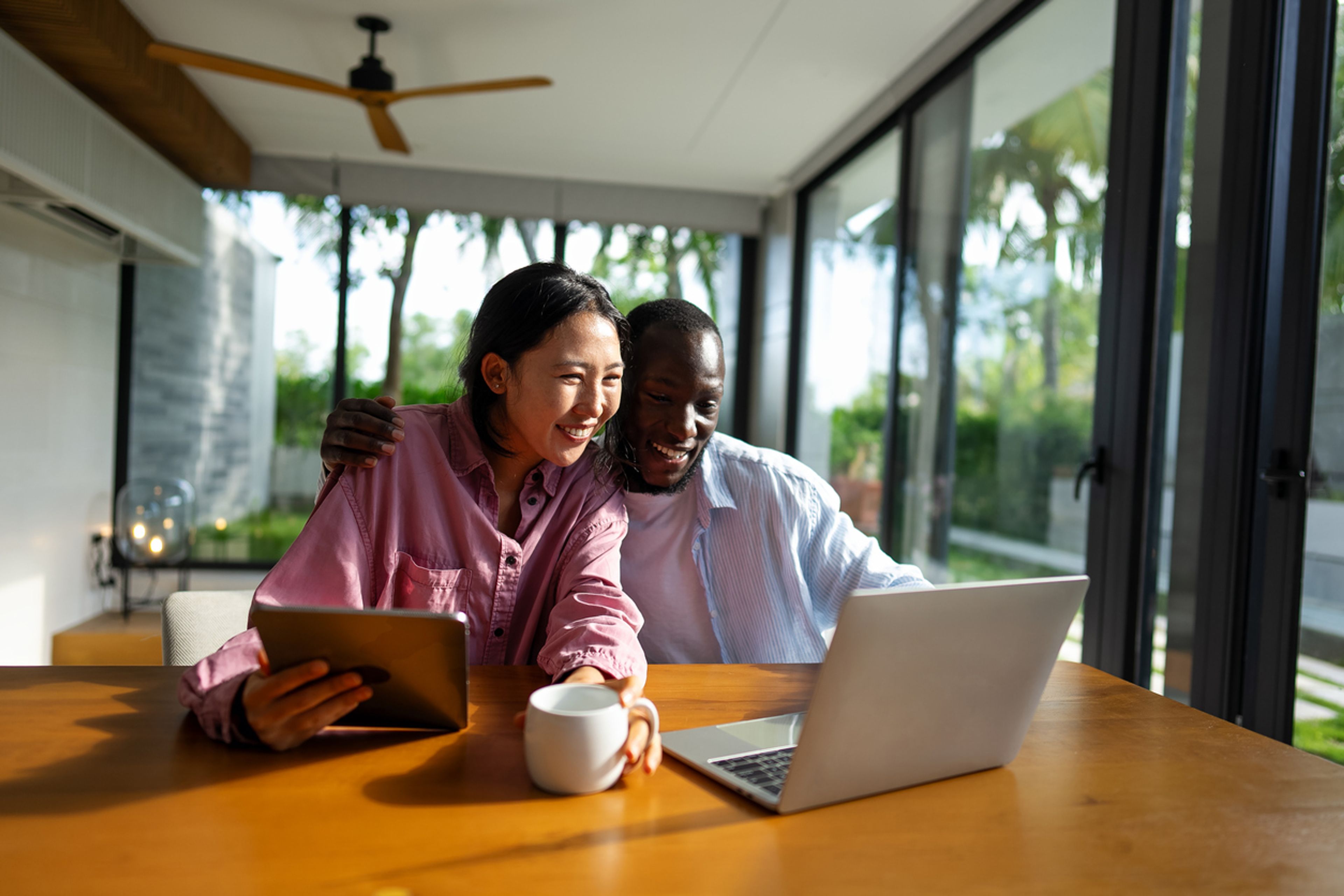 A couple looking at a laptop together and smiling excitedly.
