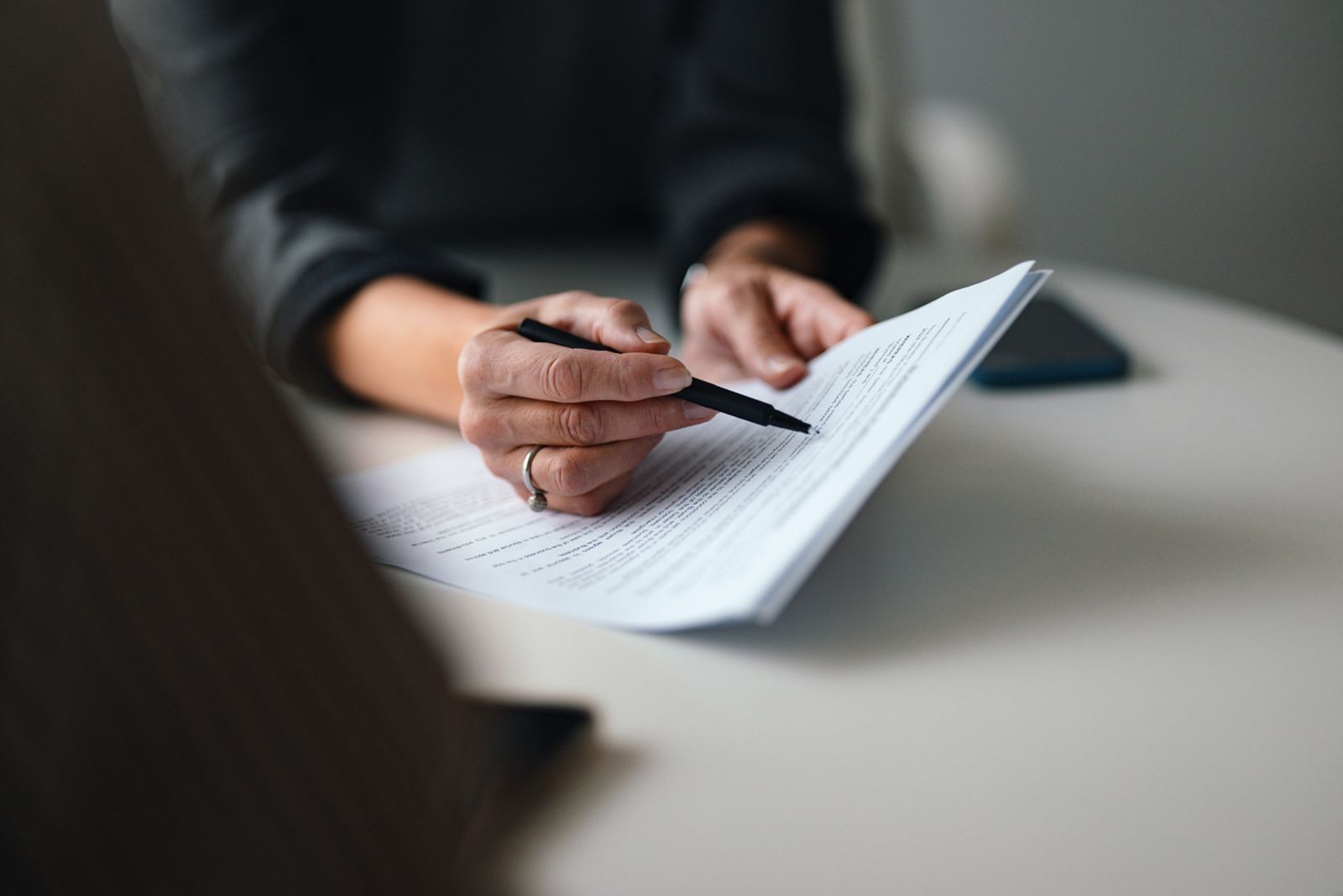 Attorney reviewing a printed document with a pen in hand