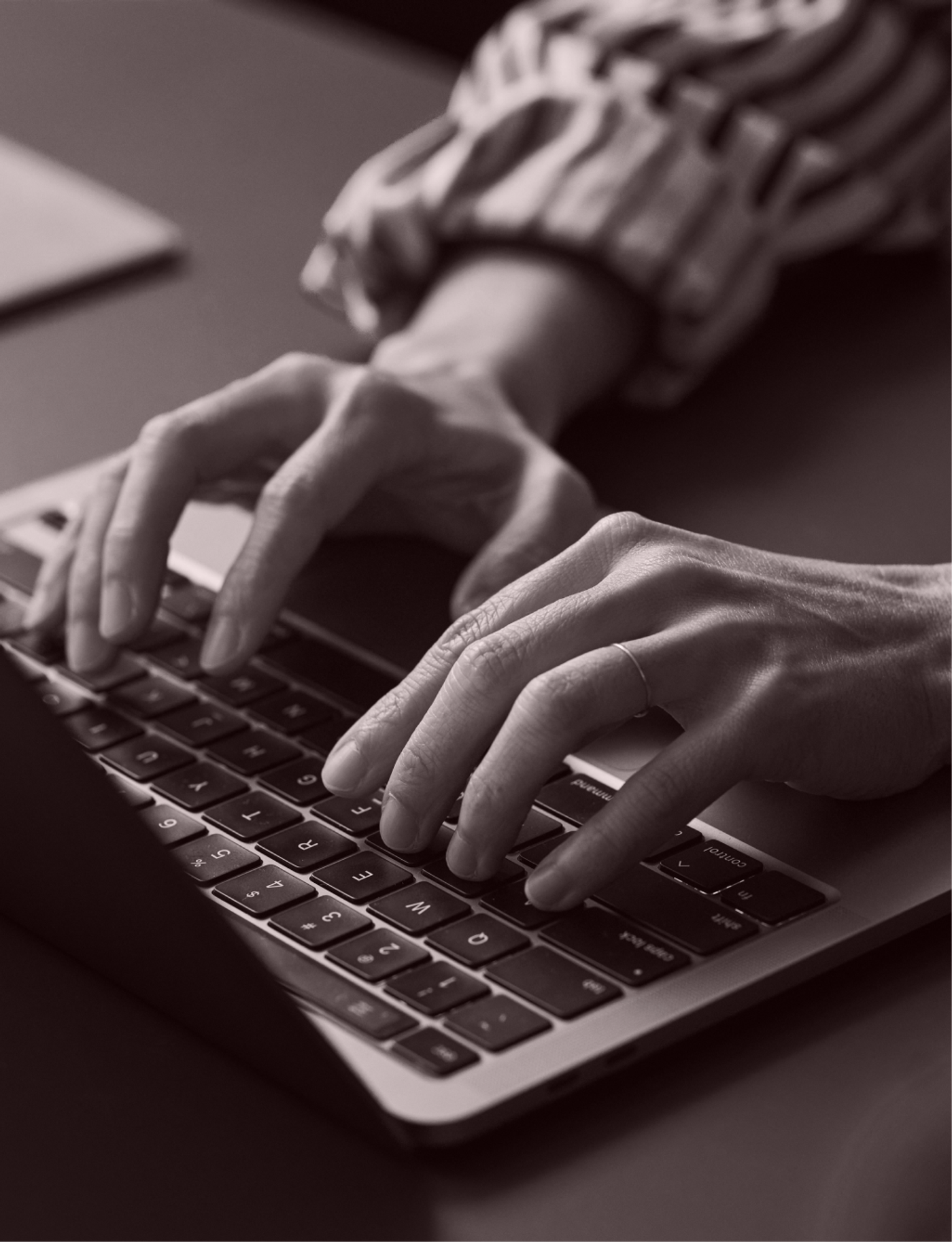 Hands typing on a laptop.