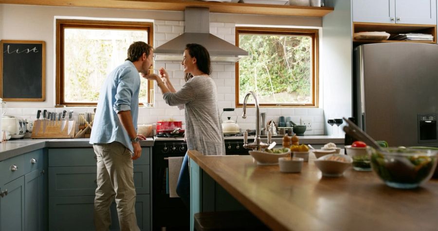 Happy couple cooking together in their kitchen.