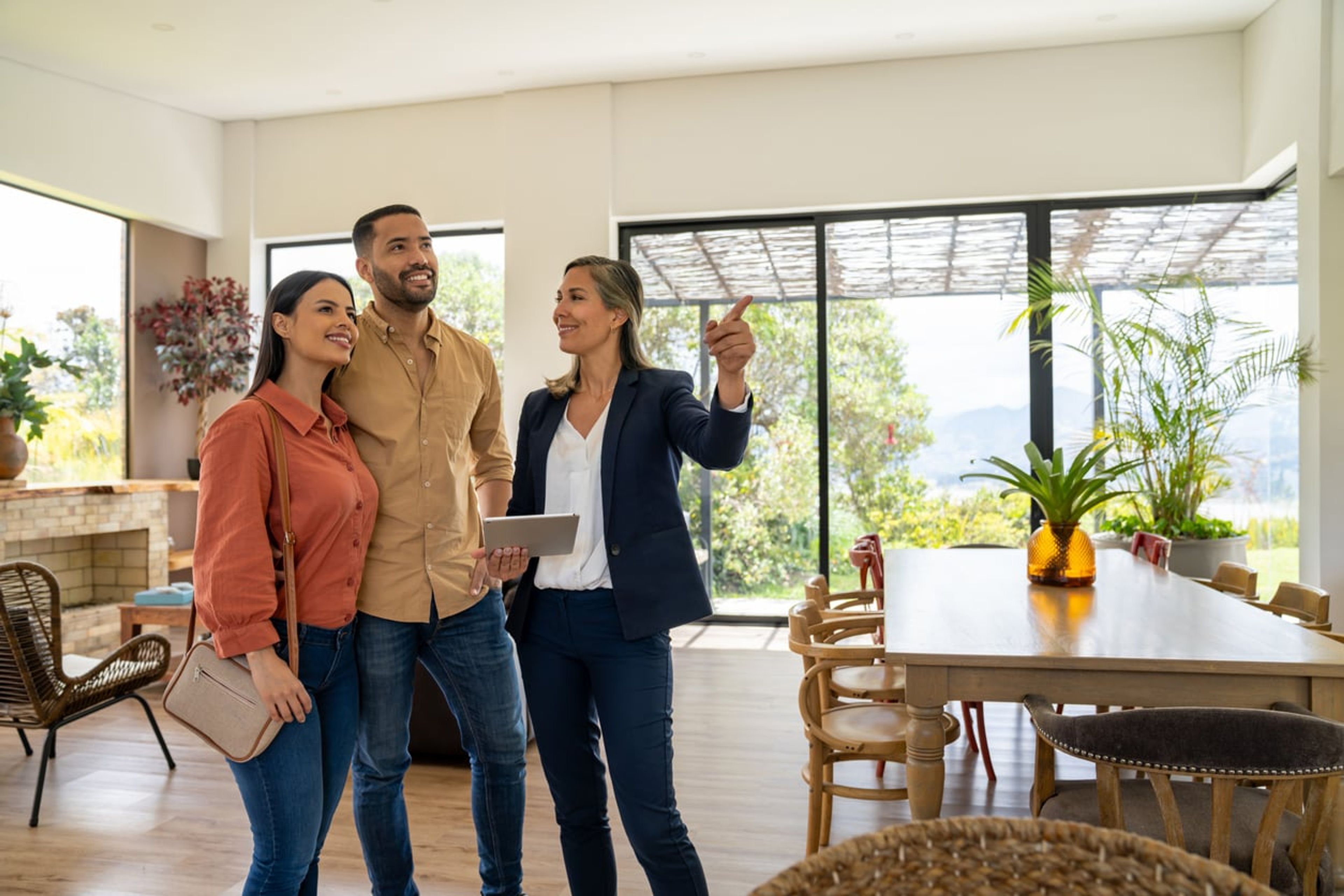 Real estate agent showing a house for sale to a young couple.