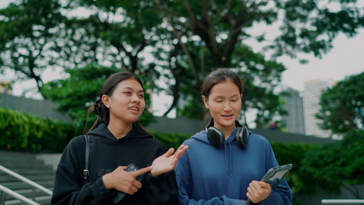 Two young women are walking and having a conversation about their OPT options on an F-1 visa.