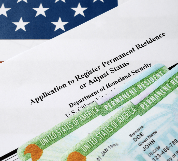 H-1B worker reviewing green card application documents with an immigration attorney