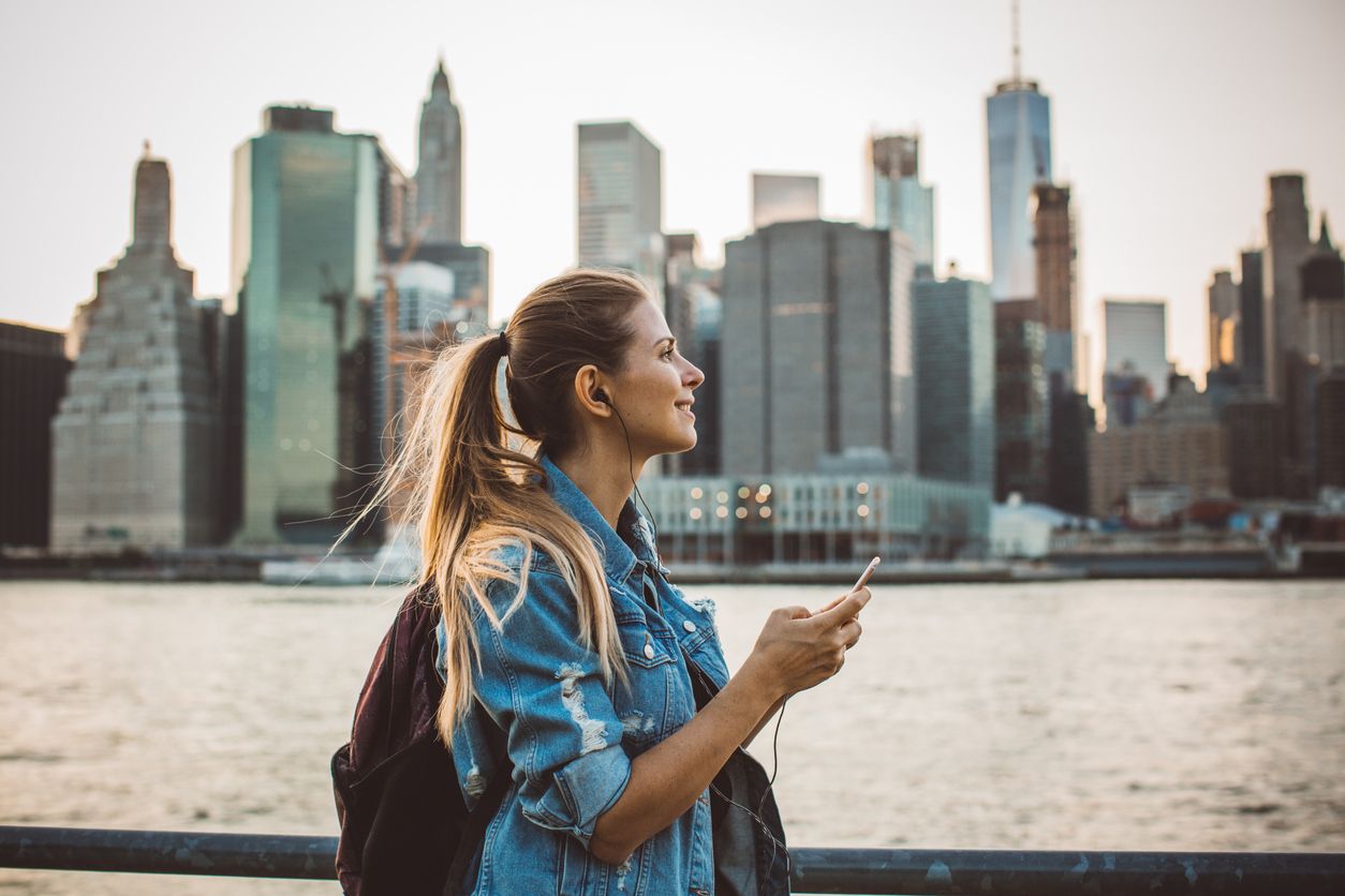 Tourist traveling to New York with the Manhattan skyline in the background.