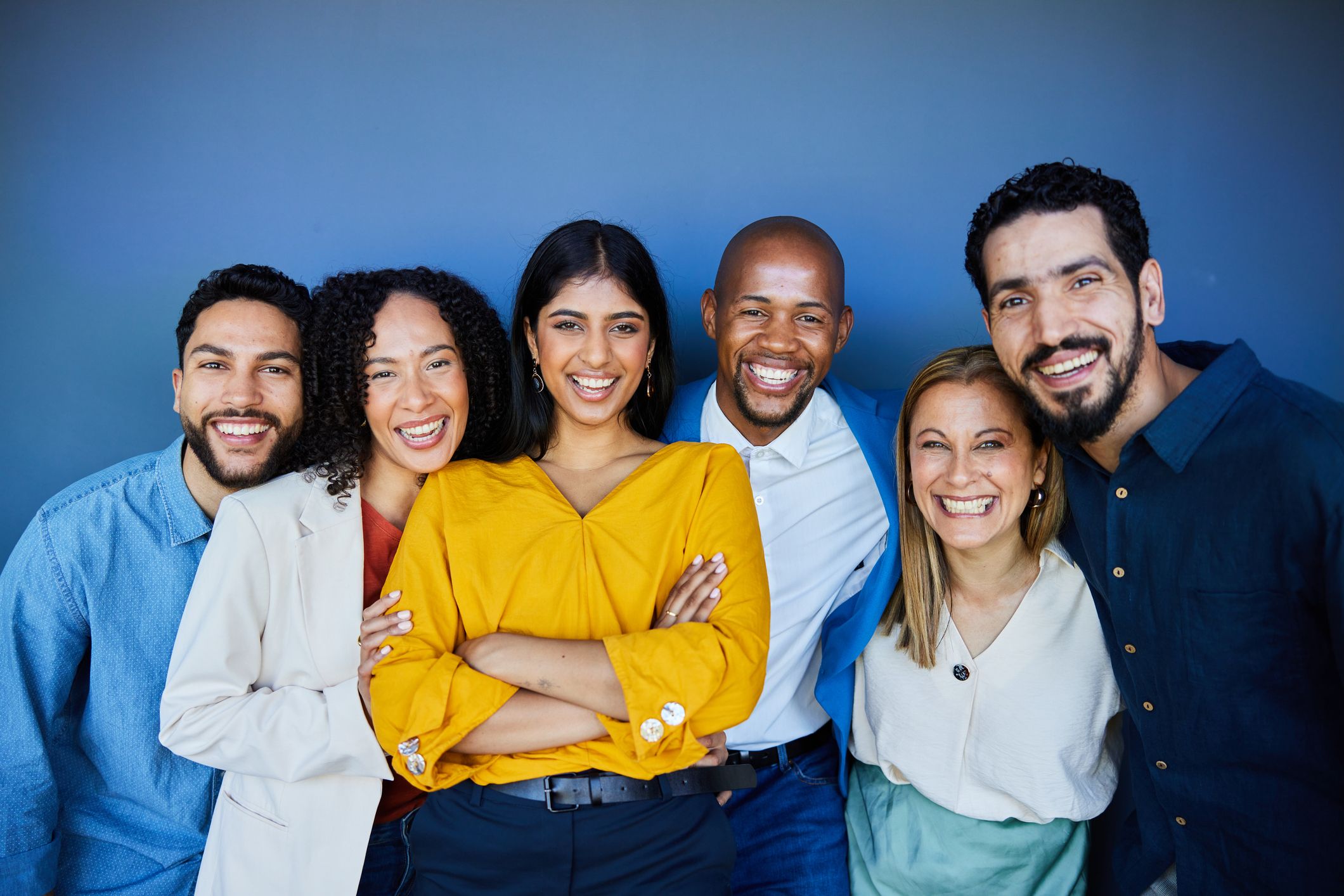 A diverse group of professionals standing together in an office.