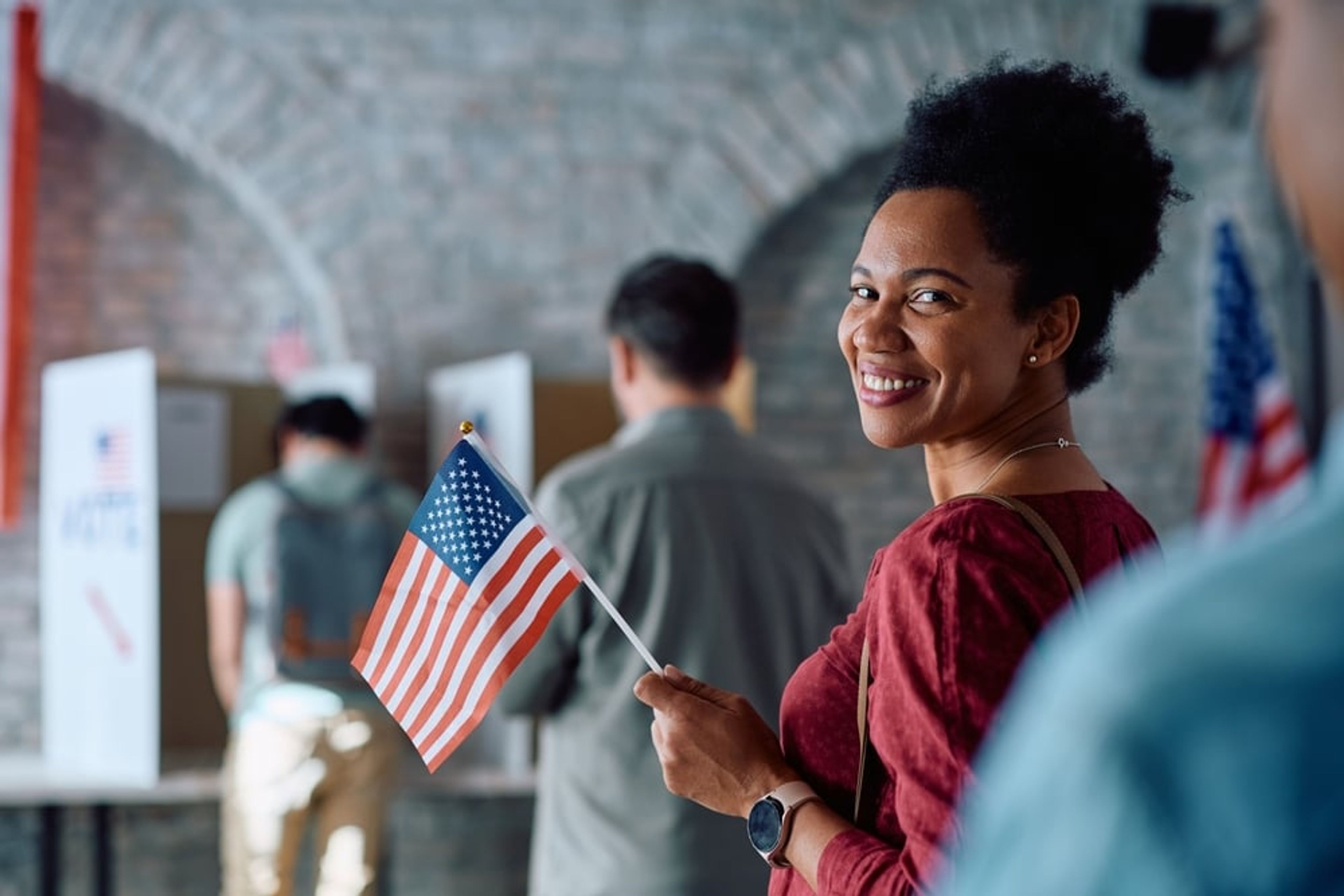 Smiling woman holding an American flag.