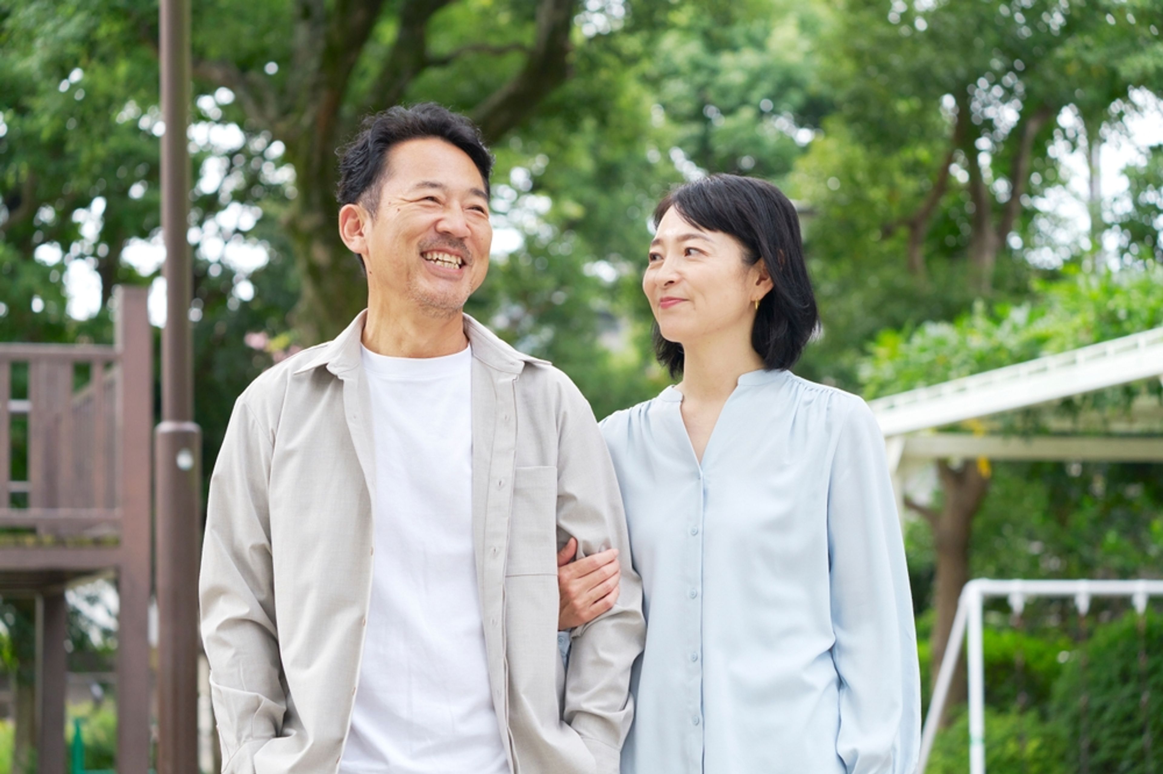 Married couple smiling at each other standing in their backyard