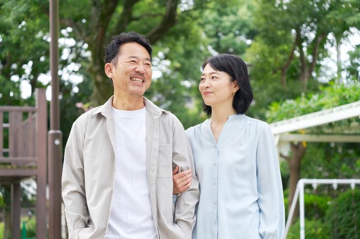 Married couple smiling at each other standing in their backyard