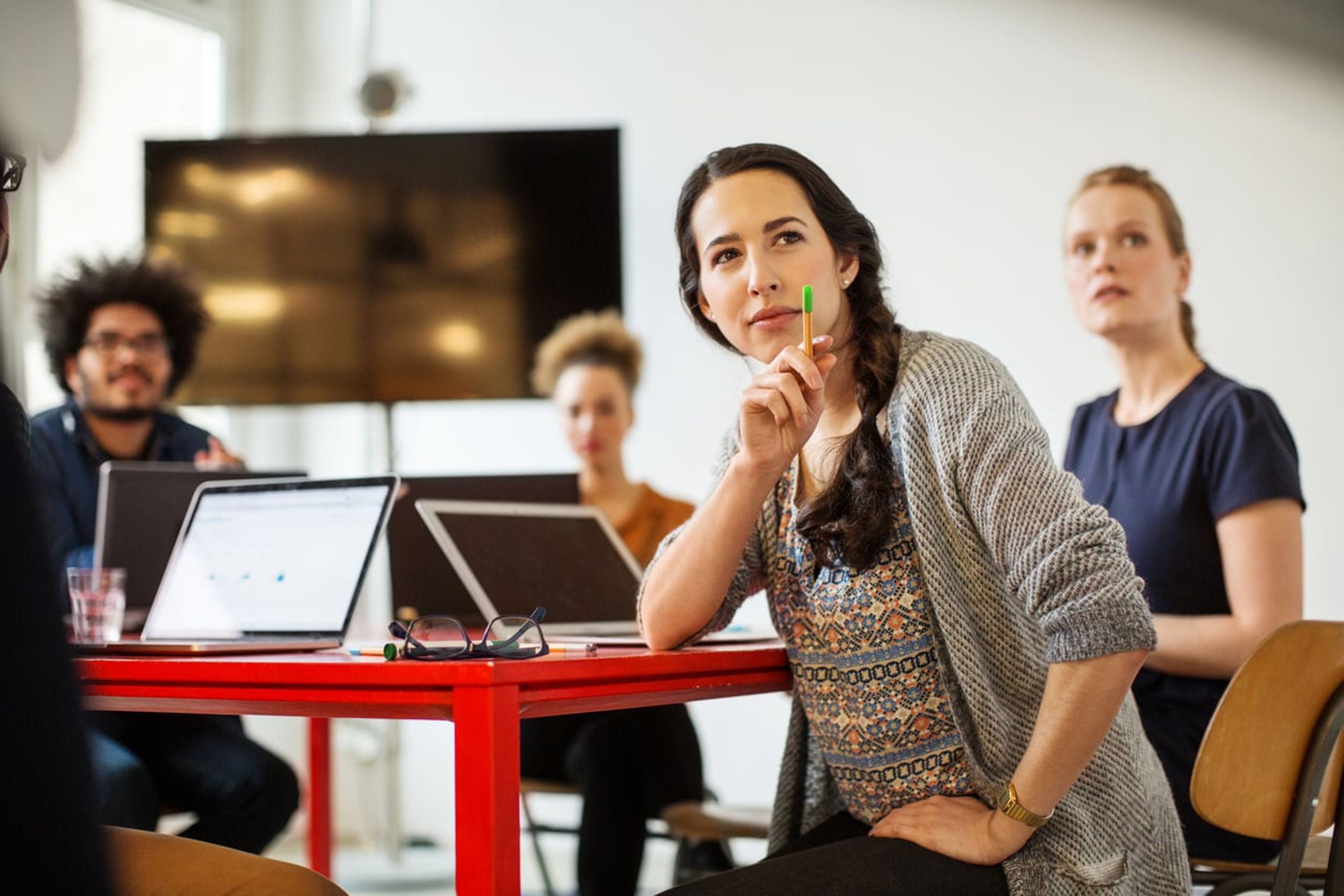Woman leading meeting of her coworkers in a startup office.