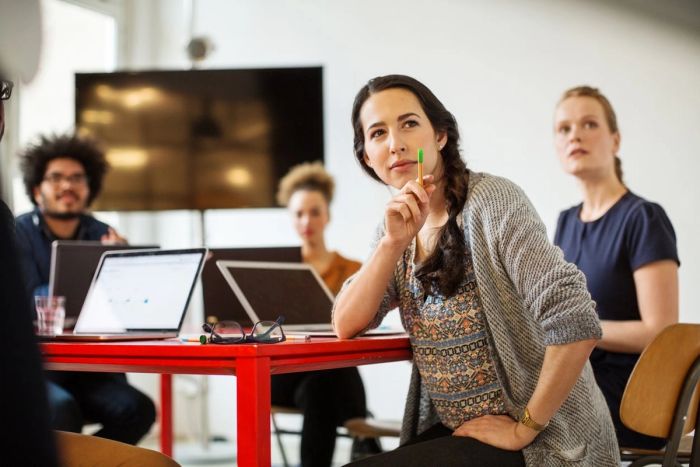 Woman leading meeting of her coworkers in a startup office.