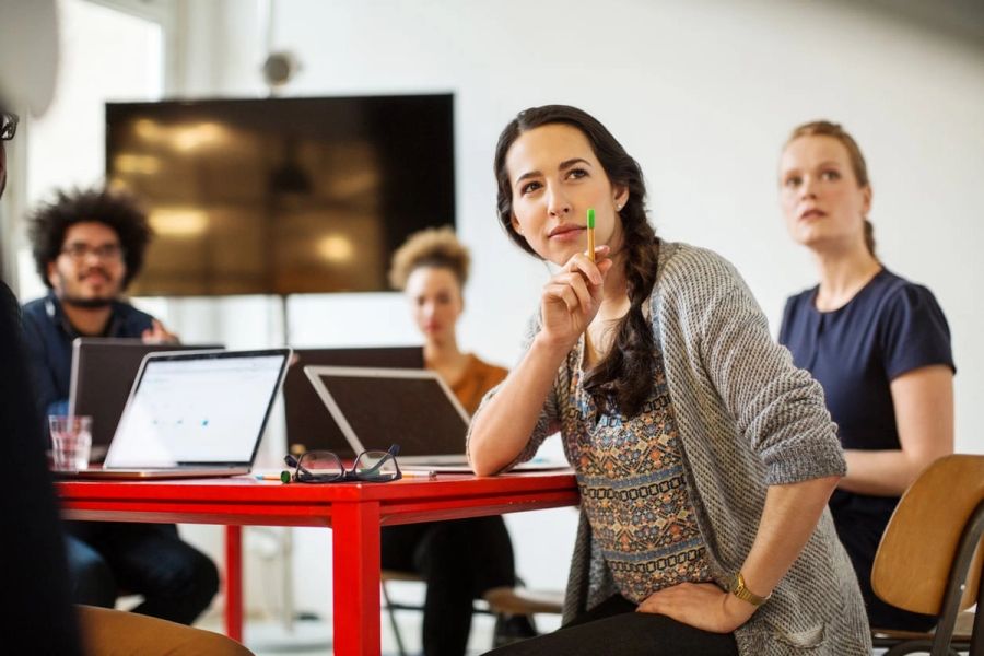 Woman leading meeting of her coworkers in a startup office.