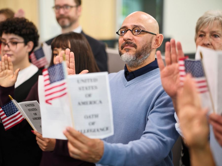 Group of new citizens taking the Oath of Allegiance at a USCIS administrative naturalization ceremony