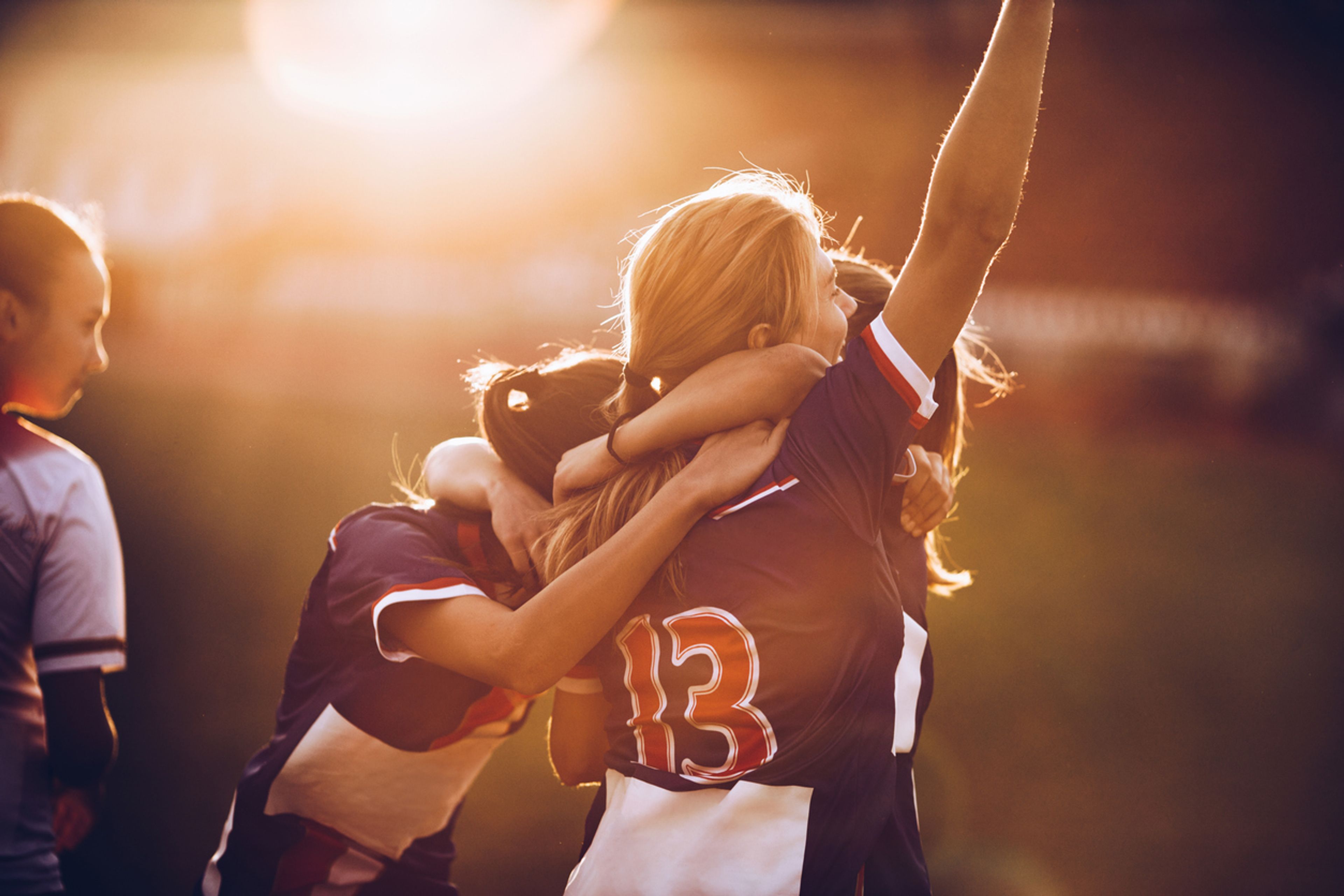 Female soccer players celebrating together.