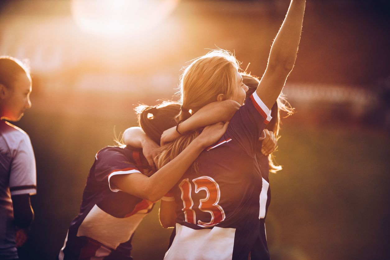 Female soccer players celebrating together.