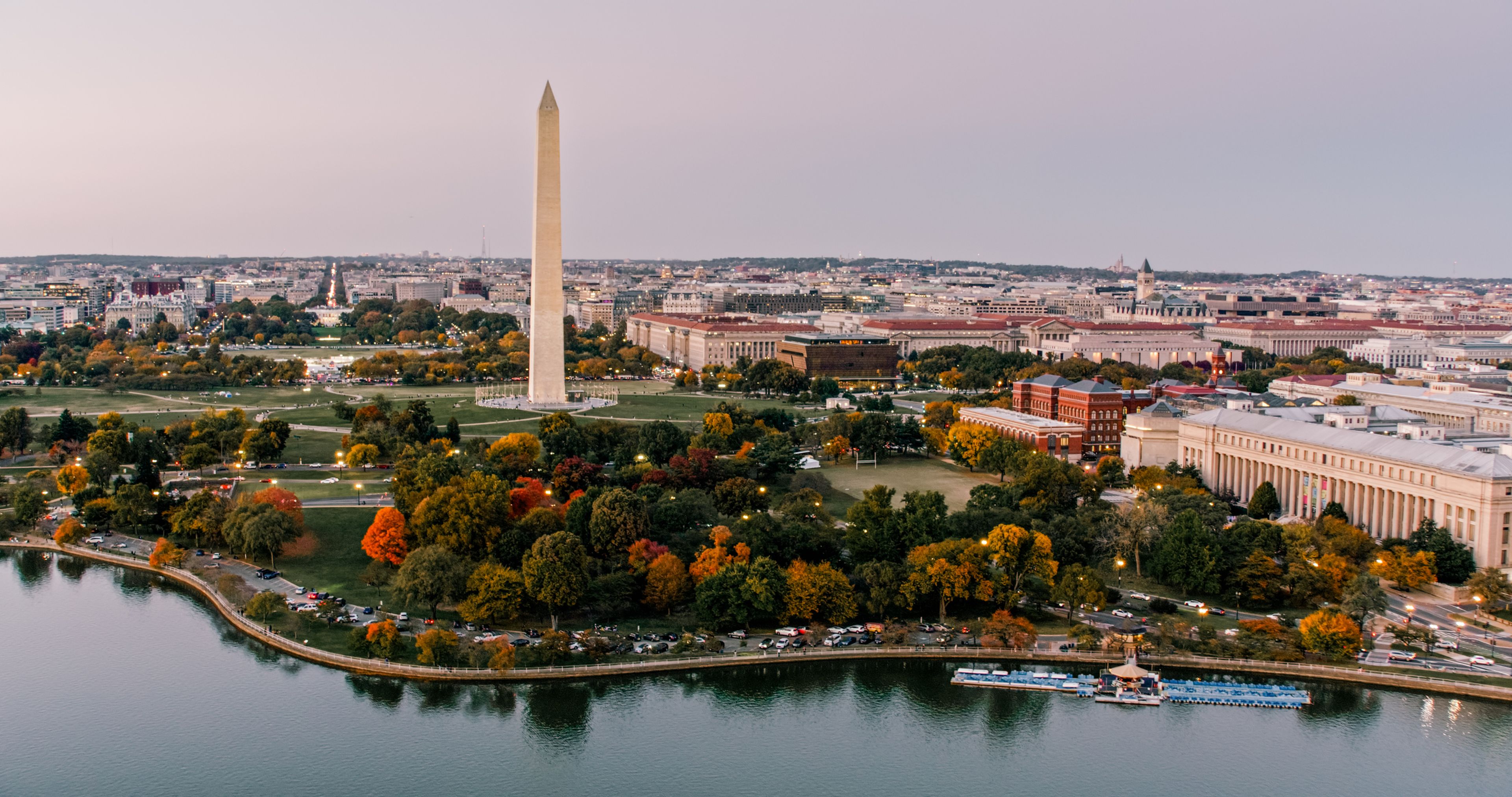 Aerial photo looking down the National Mall toward the Washington Monument, with the White House and surrounding D.C. buildings behind it