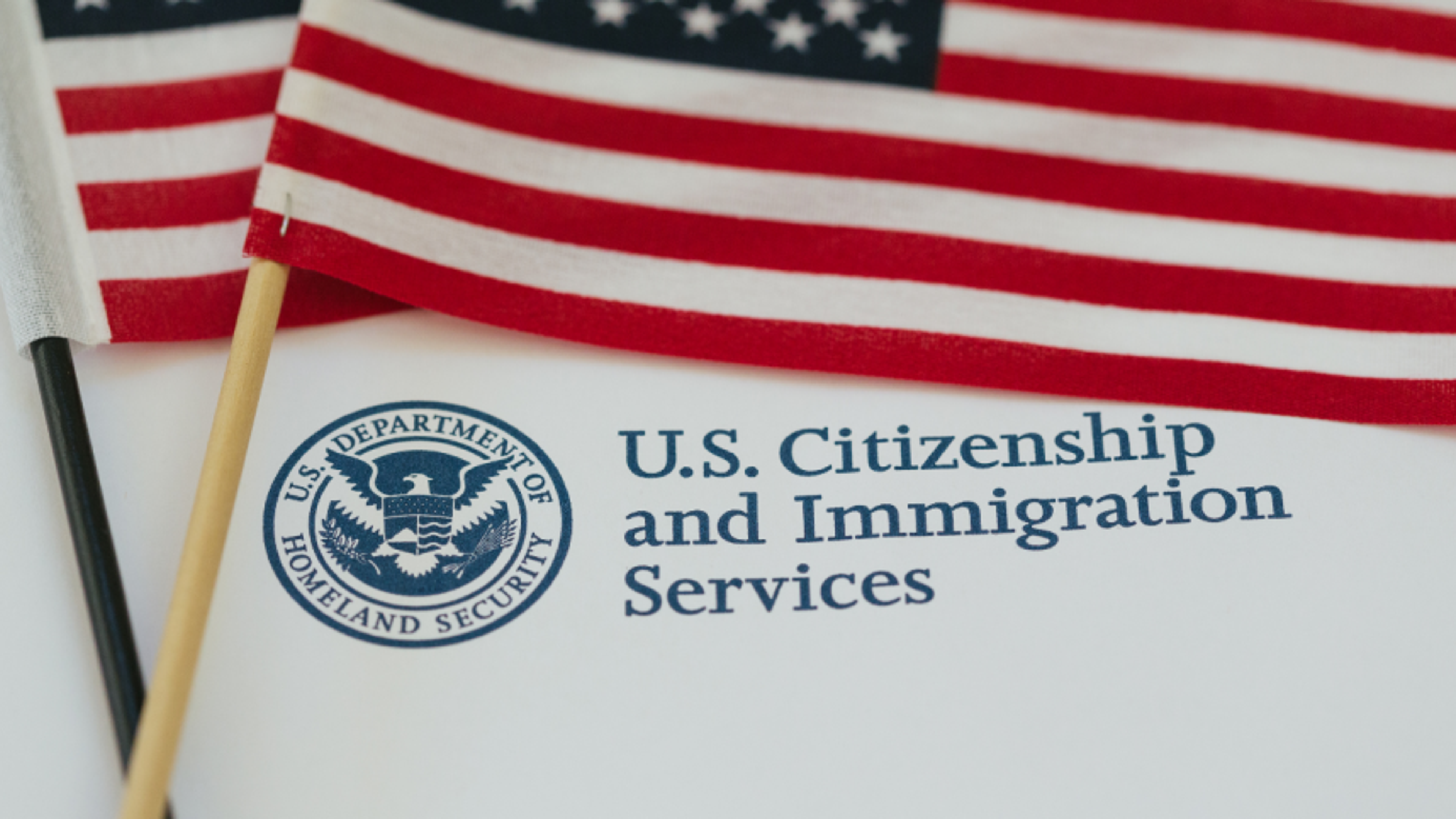 American flags laying on a USCIS document logo