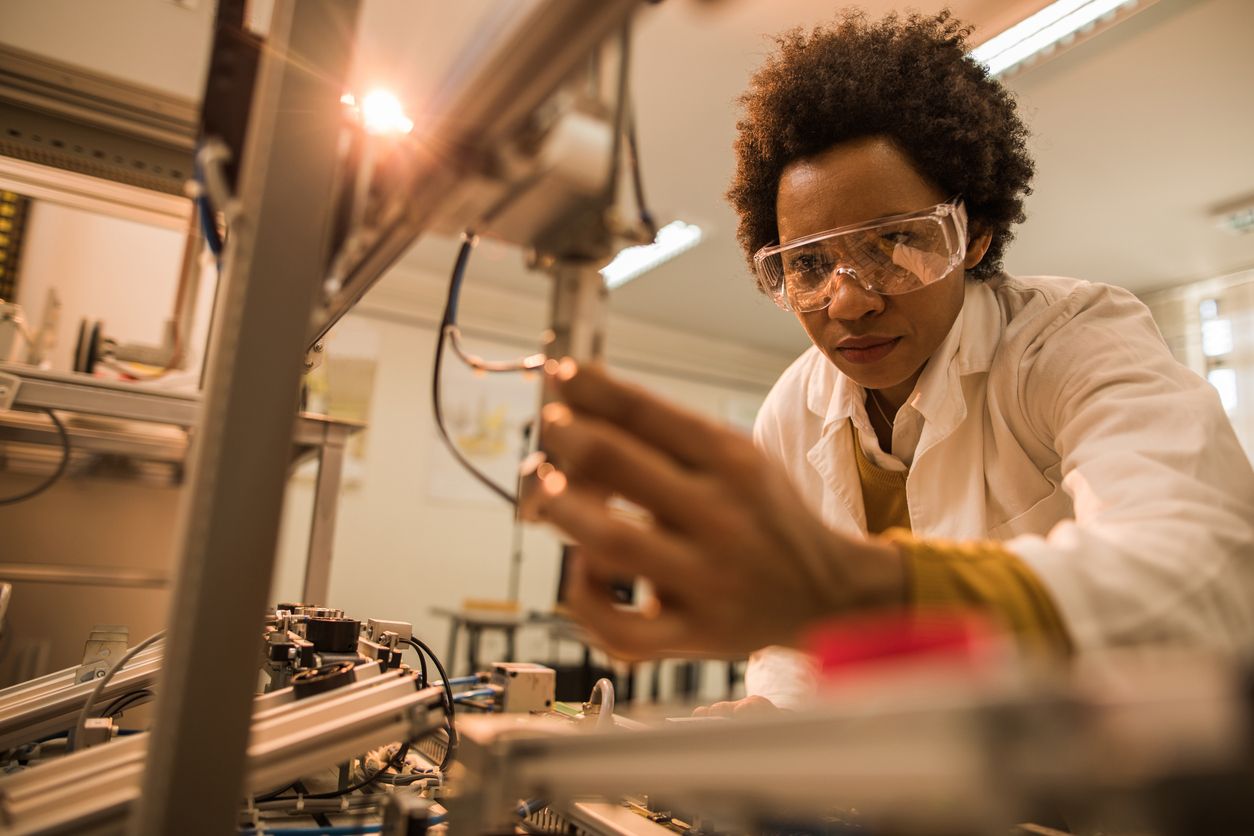 Worker using robotic equipment in a lab.