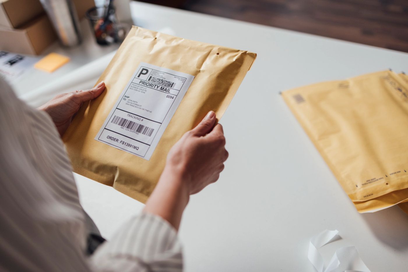 Person holding a sealed envelope before mailing it, illustrating the new DHS rule letting USCIS require e-filing instead of paper immigration forms