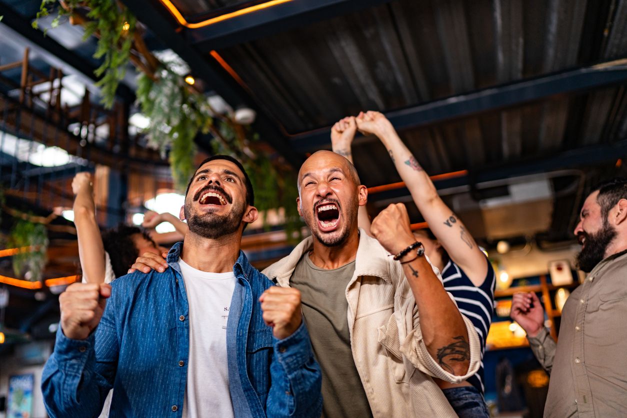 Friends watching the World Cup and celebrating at bar