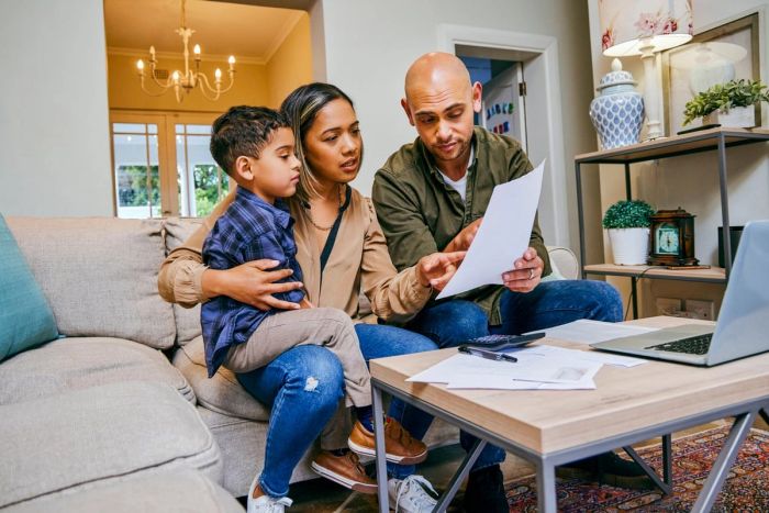 Young married couple reviewing documents together with their child.