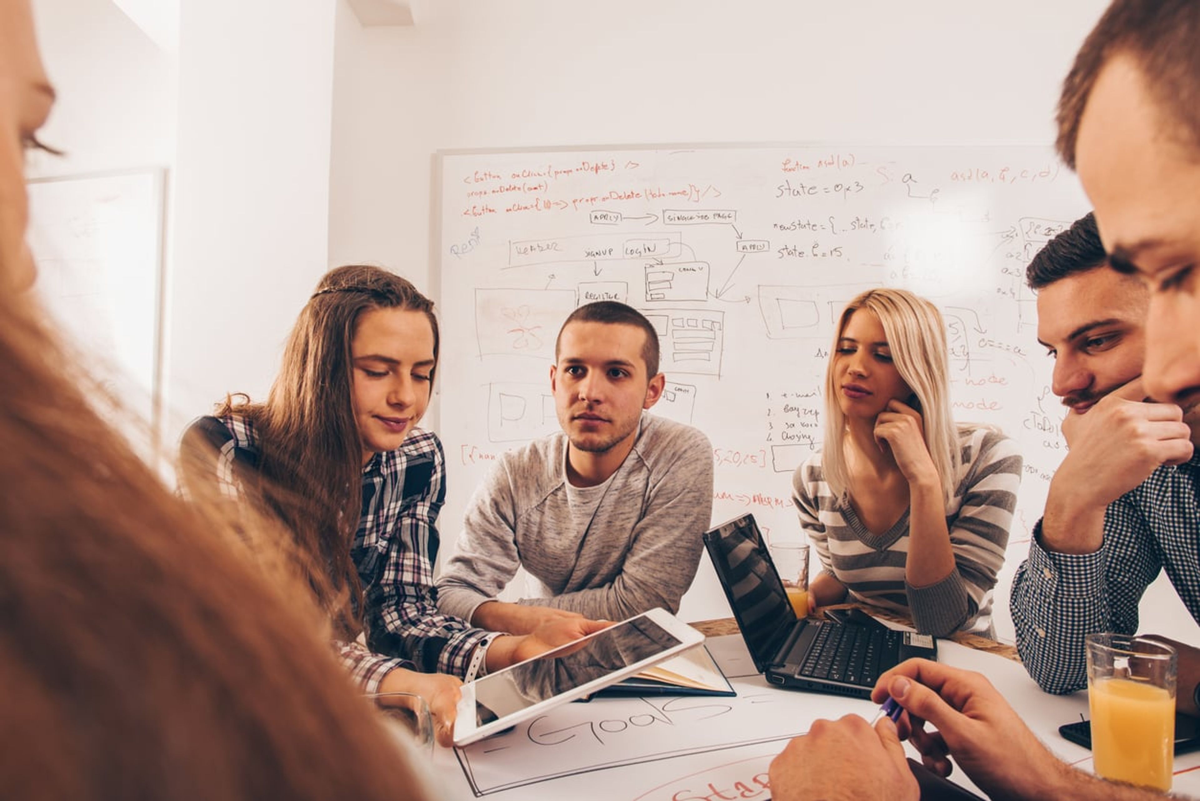 Tech entrepreneurs assessing each other's code in a conference room.