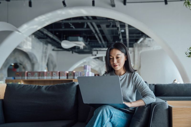 A founder works on a laptop in a modern coworking space while considering U.S. visa options.