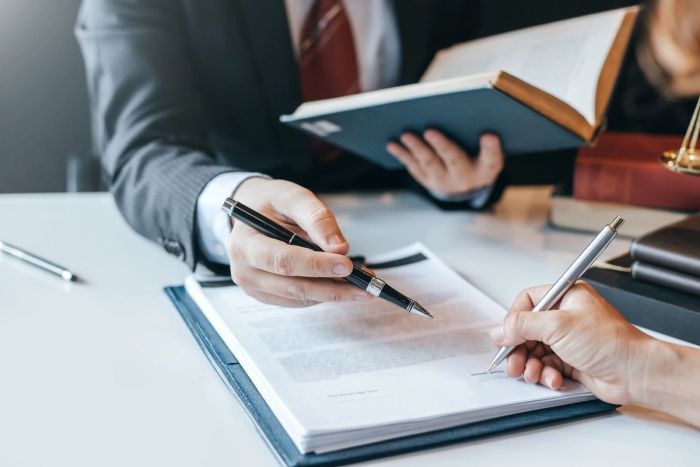 Businessman and lawyer discuss the contract document.