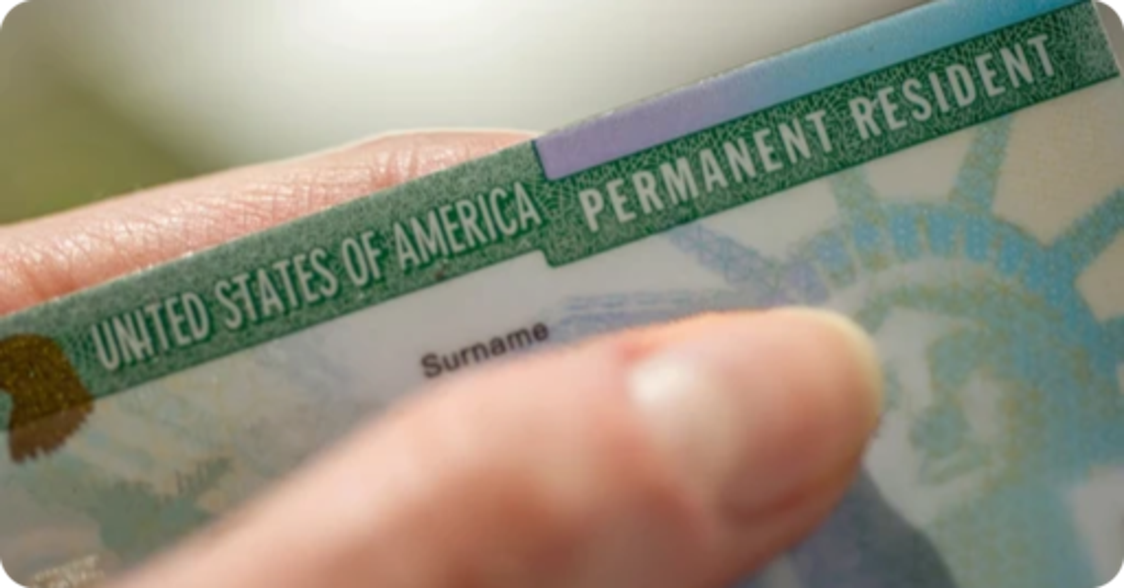 Green card on application documents, illustrating the E-1 visa to green card path