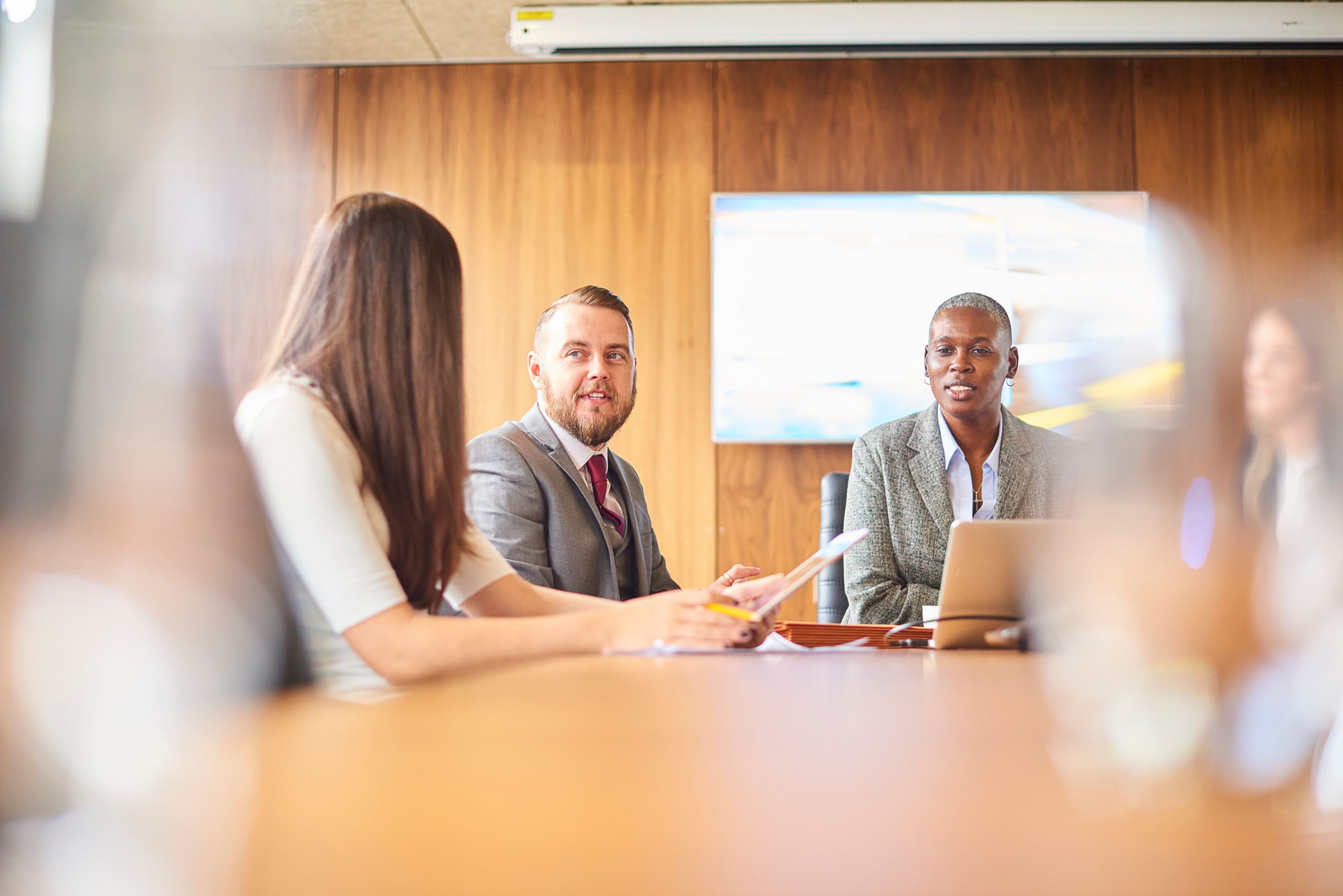 Team in a boardroom sat round a conference table