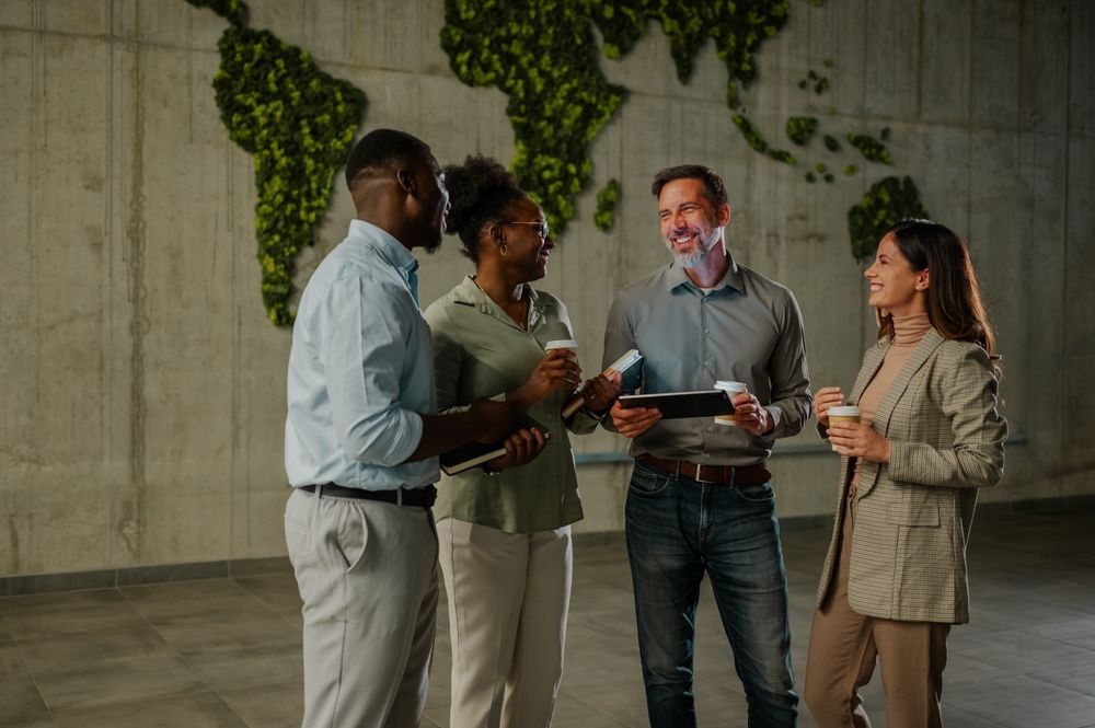 Four workers meeting together in an office for a standup.