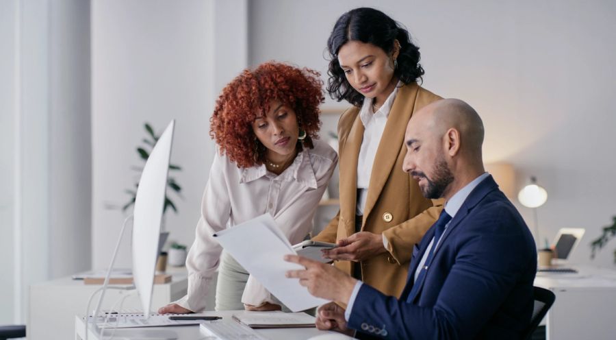 A business team reviewing documents together in a bright office.