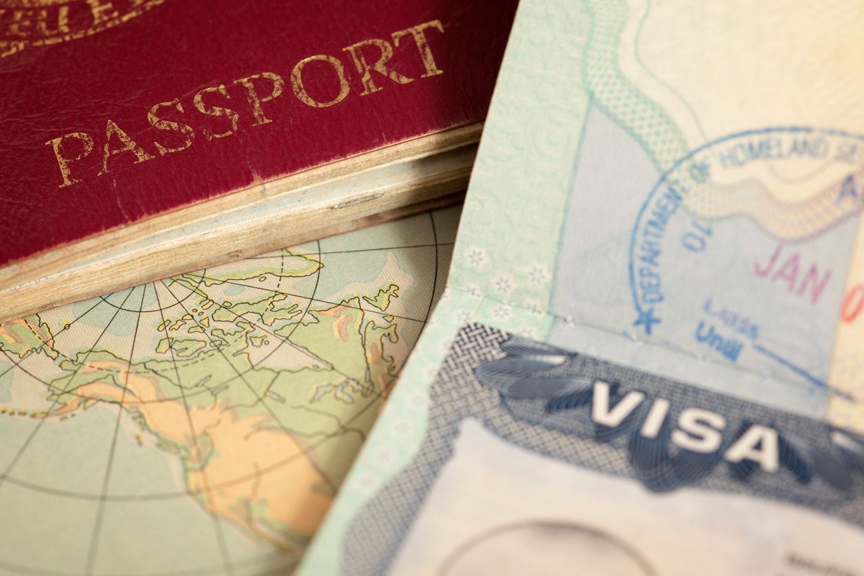 Closeup of a passport cover next to a visa stamped by the Department of Homeland Security
