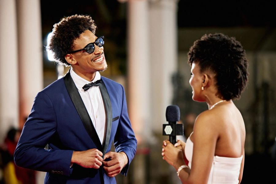 Celebrity giving an interview on the red carpet at an event.