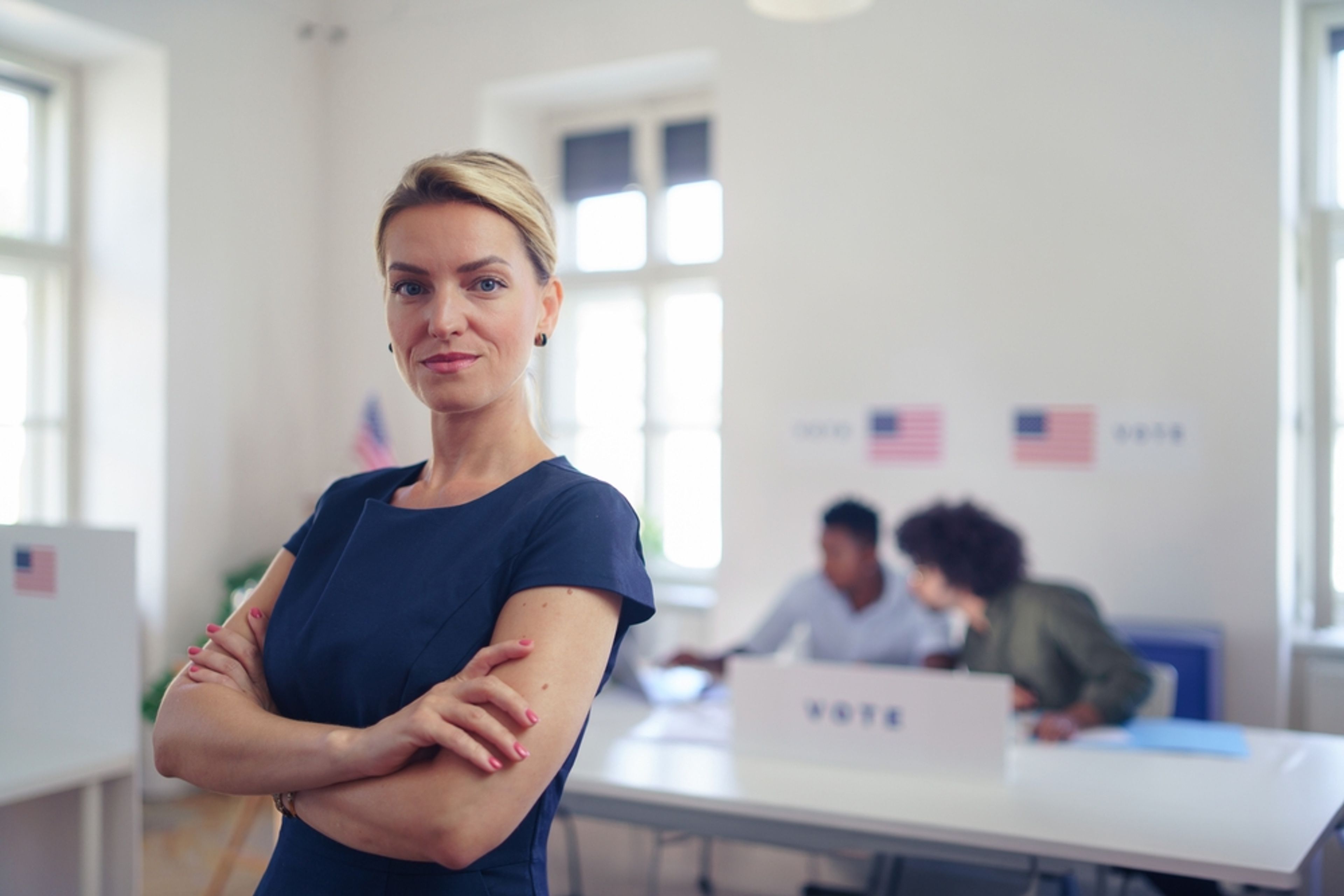 Woman standing in front of the registration table at her polling location.