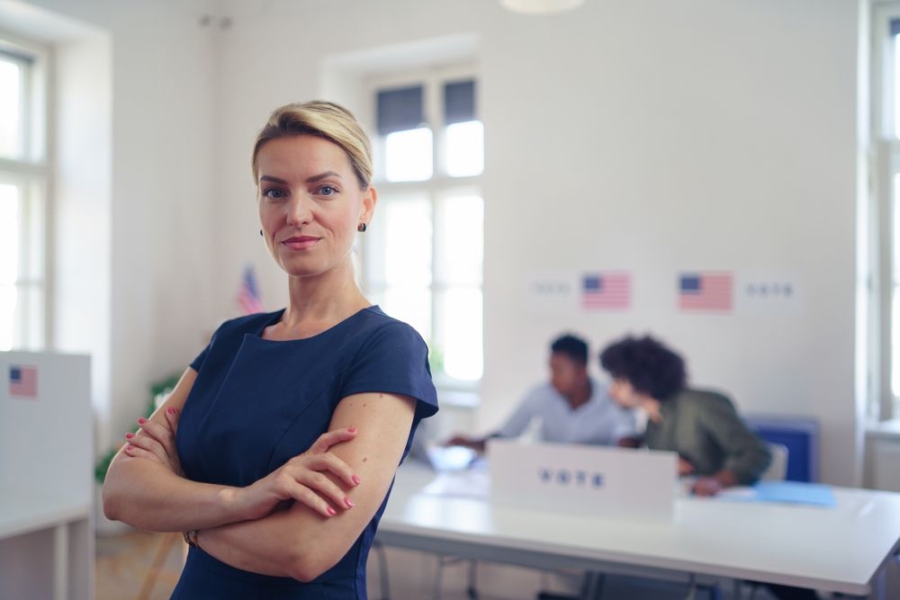 Woman standing in front of the registration table at her polling location.