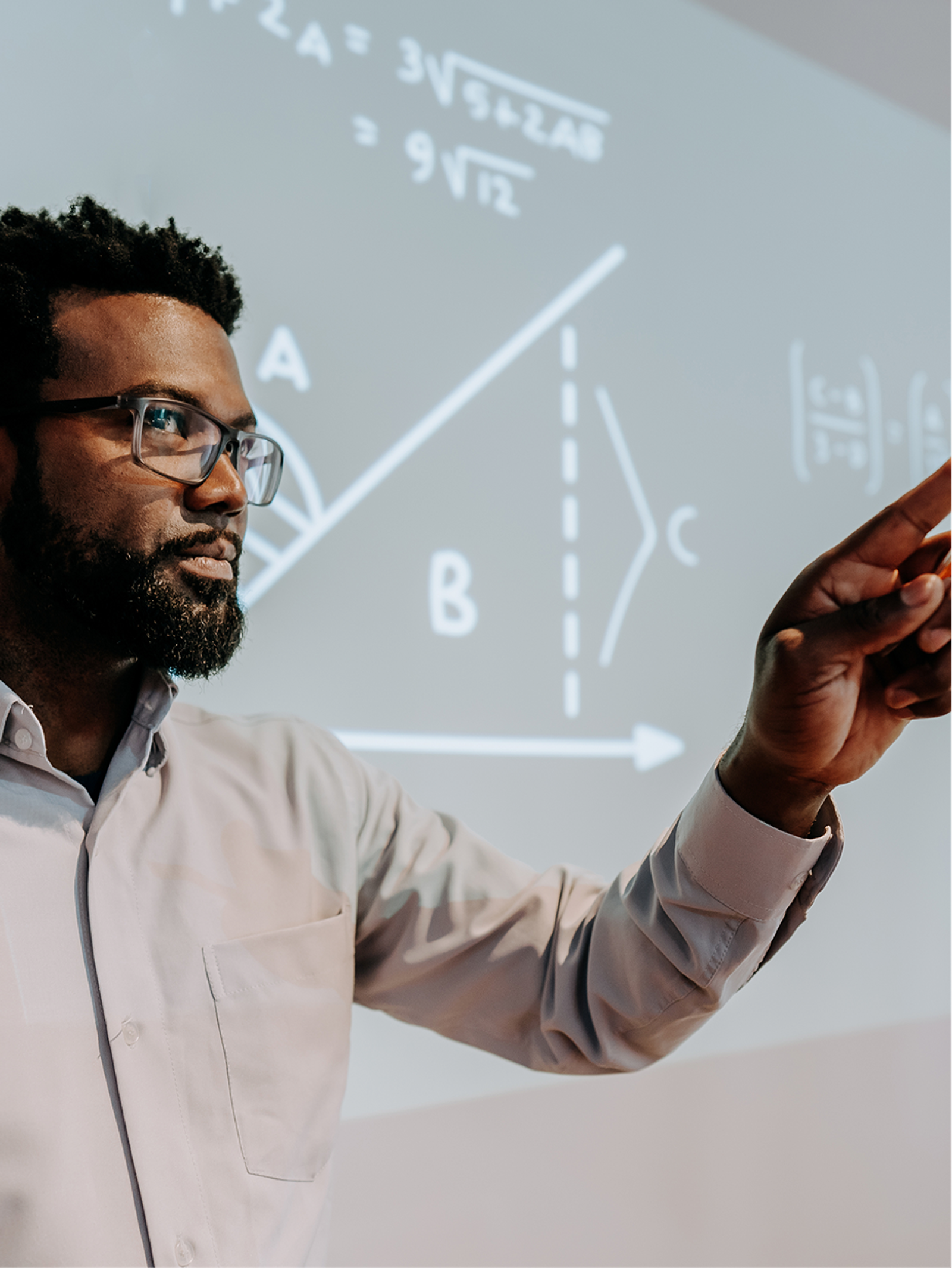A professor explaining equations projected on a screen