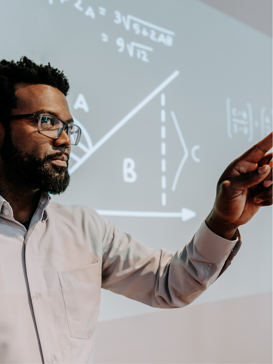 A professor explaining equations projected on a screen