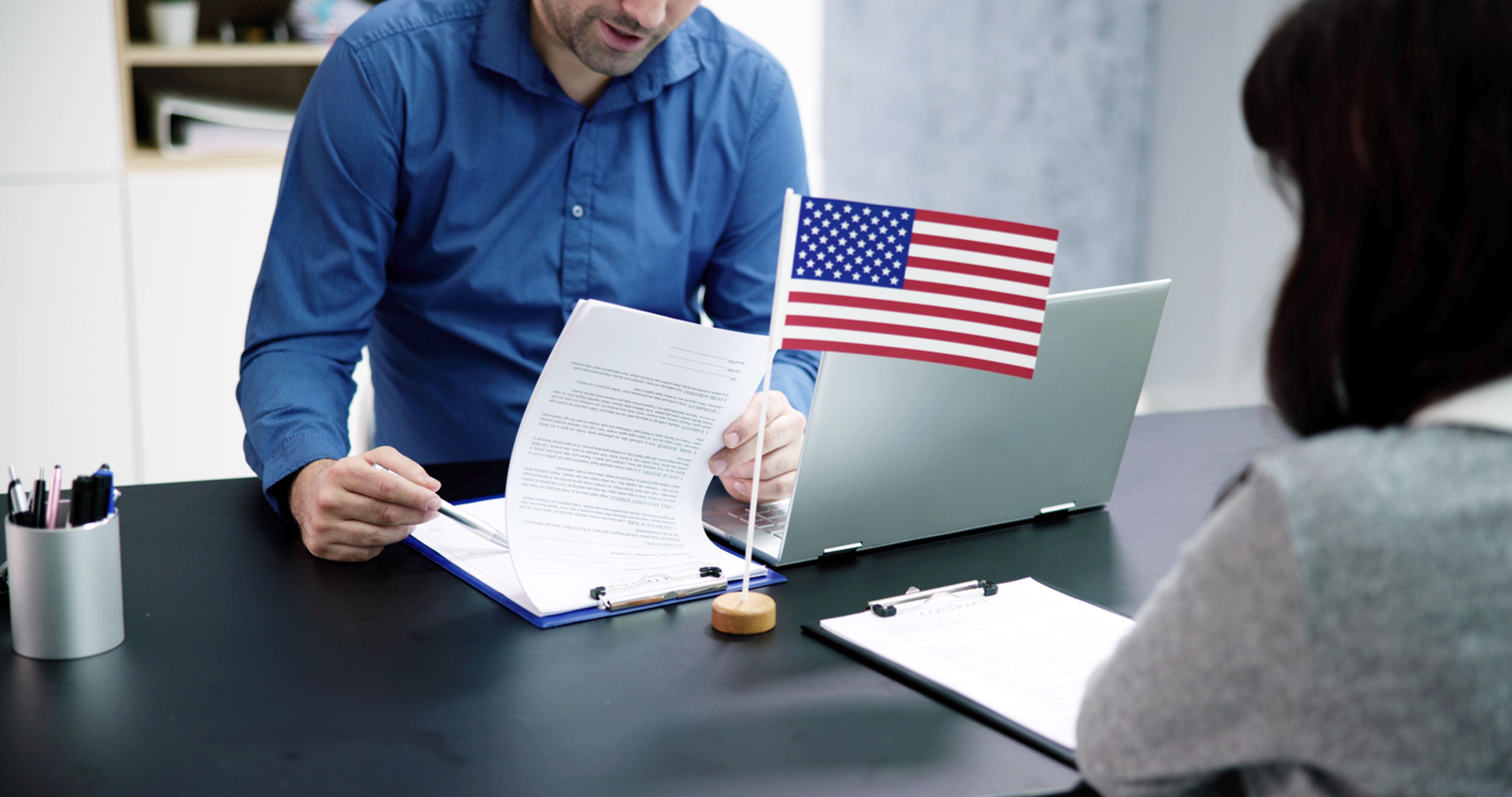 Immigration interview with officer looking over documents.