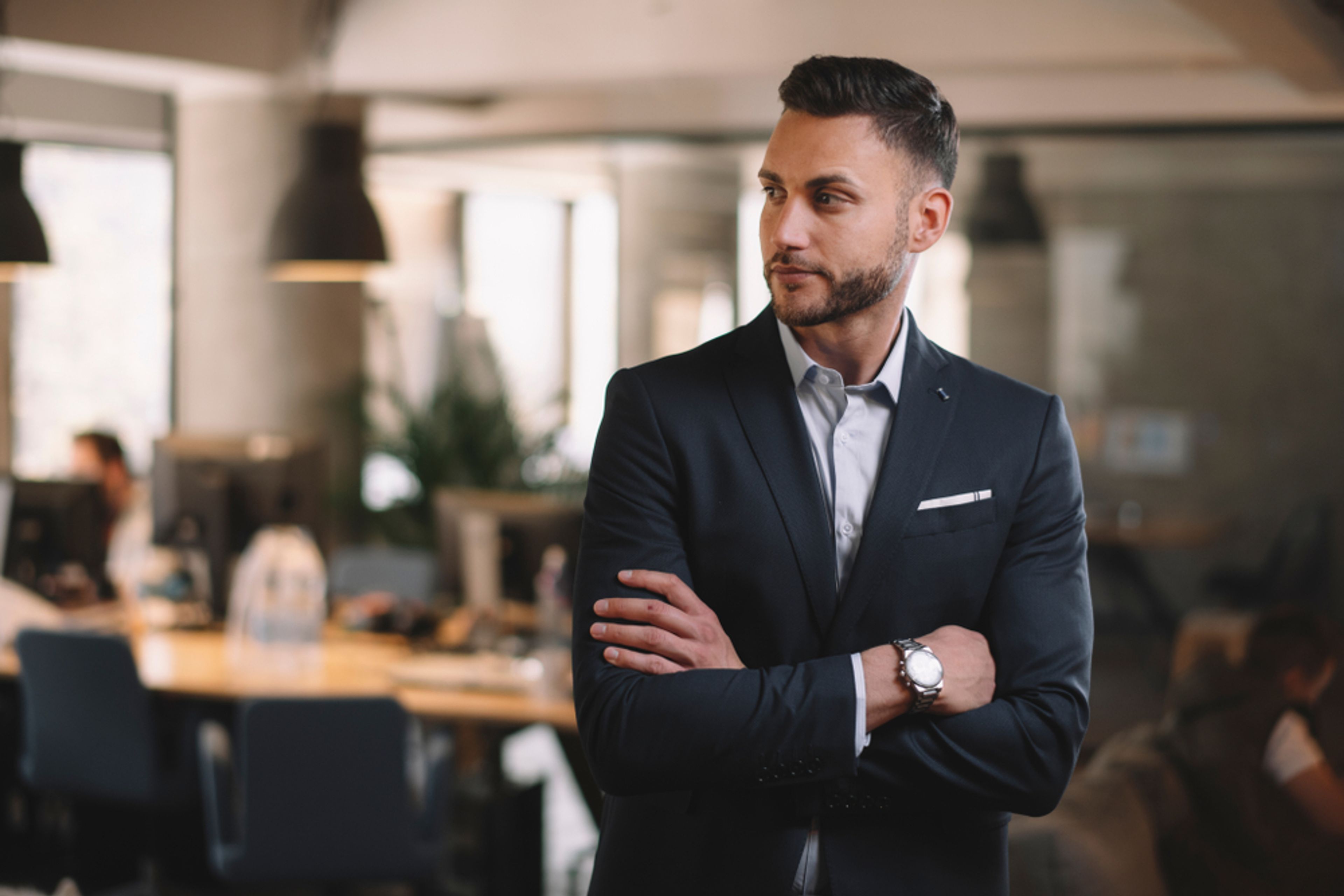 Man wearing a suit standing in a modern office.