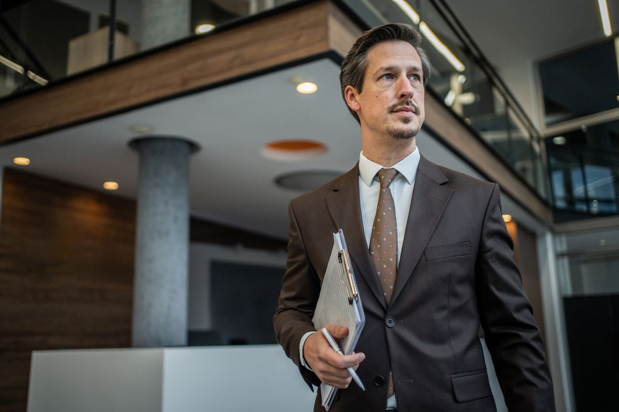 Confident businessman holding a clipboard and pen.