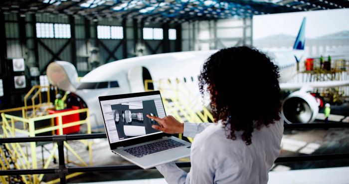Aerospace engineer reviewing designs on her laptop.